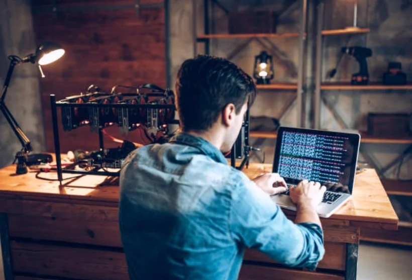 Yazılım geliştirici bir bilgisayar laptop karşısında oturup kod yazıyor